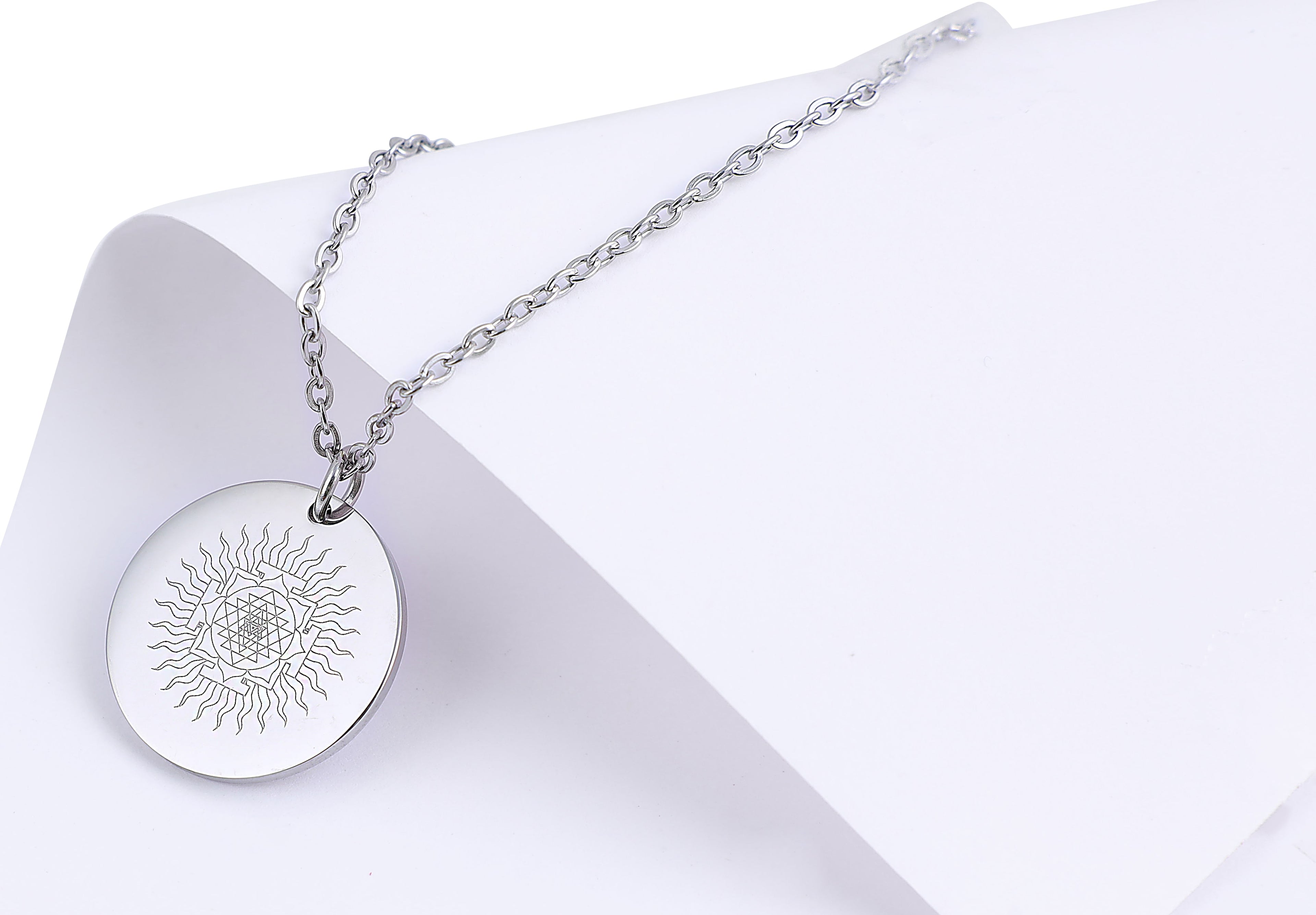 Silver necklace with a round pendant on a white background